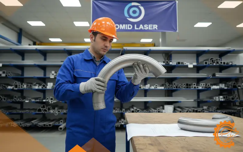 کارگر در حال بررسی دقیق کیفیت و شعاع خم لوله فلزی خمکاری شده با استفاده از ابزار اندازه‌گیری در بخش کنترل کیفیت کارگاه.